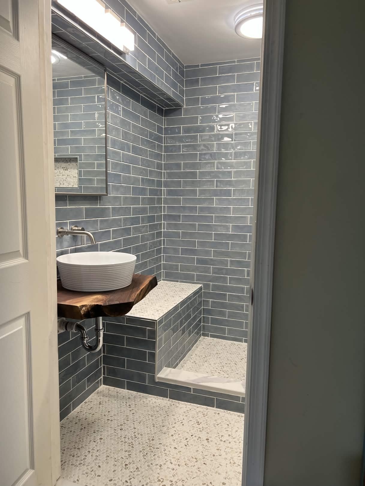 Blue subway tile shower with live-edge vanity