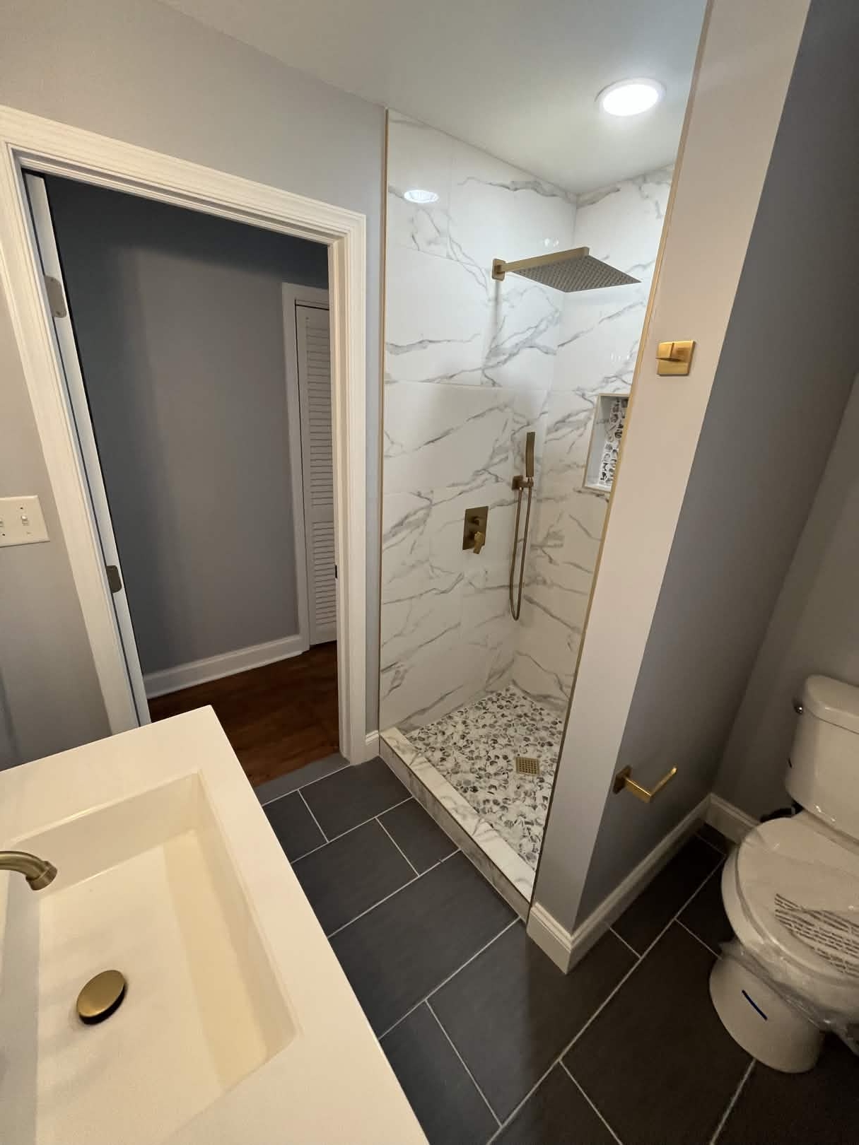 Marble walk-in shower with brushed gold trim
